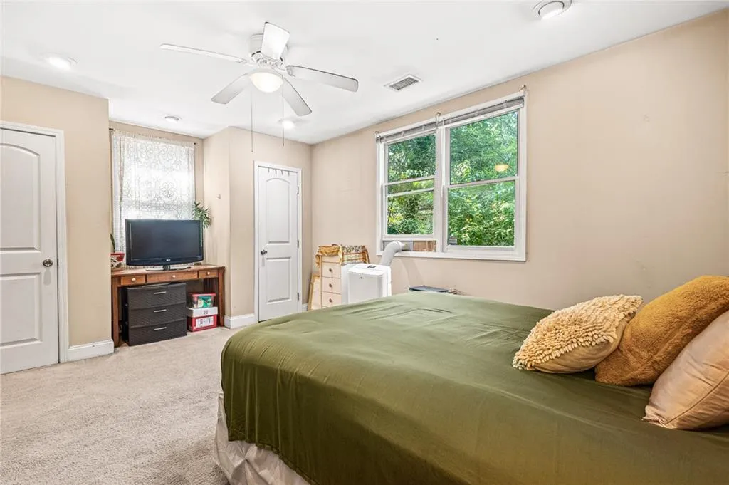 Carpeted bedroom featuring baseboards and a ceiling fan