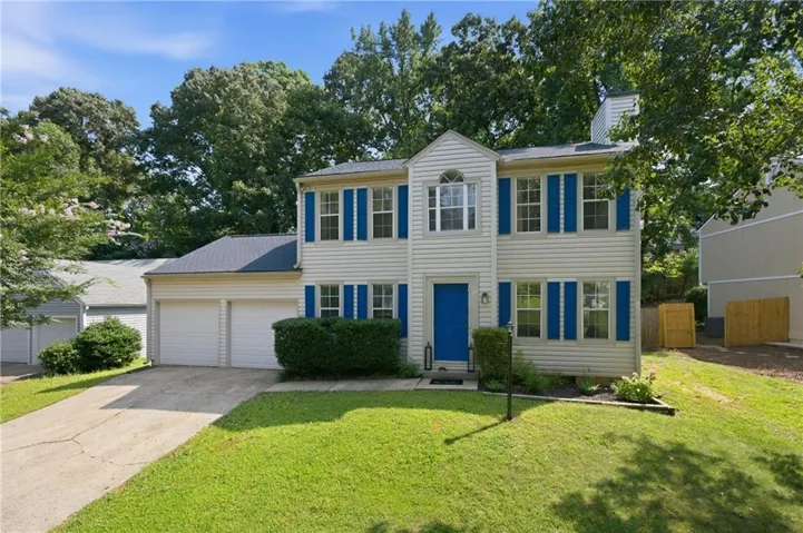 Two-story residence featuring light-colored siding, contrasting blue shutters, and a matching blue front door