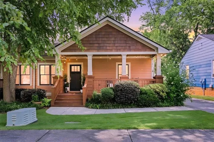 Craftsman-style home featuring a covered front porch with wood railings and substantial columns