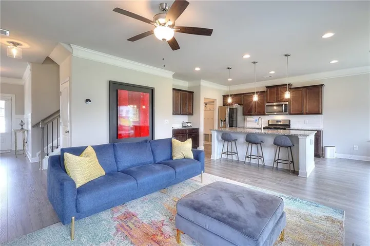 Open-concept living space featuring wood-finish flooring, recessed lighting, and a ceiling fan