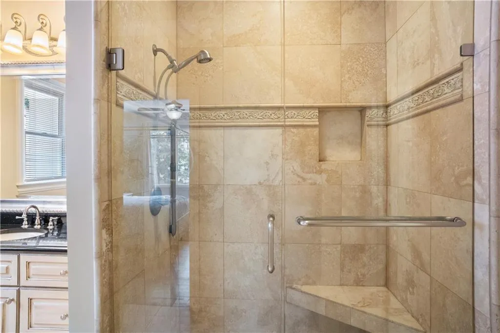 Bathroom featuring vanity and a shower with shower door Bathroom featuring vanity and a shower with shower door