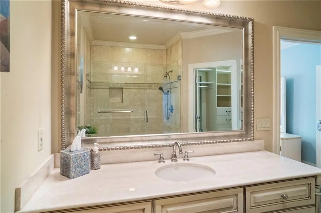 Bathroom featuring an enclosed shower, crown molding, and vanity Bathroom featuring an enclosed shower, crown molding, and vanity