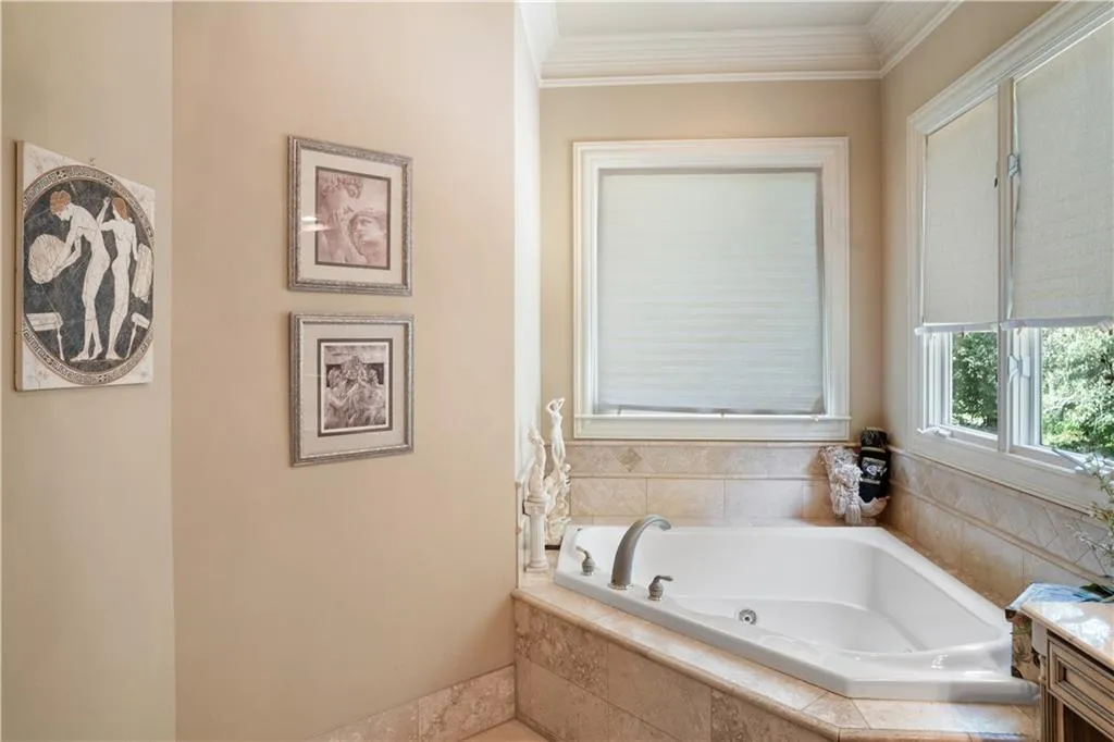 Bathroom with a relaxing tiled tub, crown molding, and vanity Bathroom with a relaxing tiled tub, crown molding, and vanity