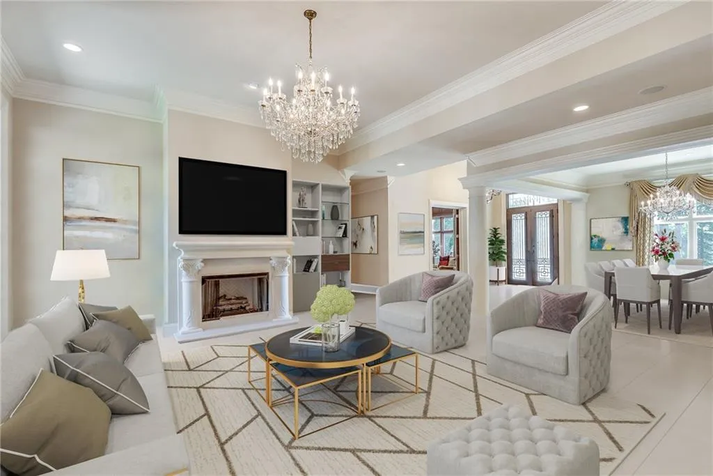 Living room with ornate columns, crown molding, and a chandelier Living room with ornate columns, crown molding, and a chandelier