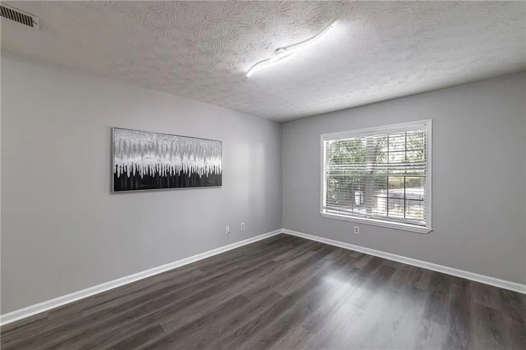 Unfurnished room featuring dark wood-style floors and a textured ceiling