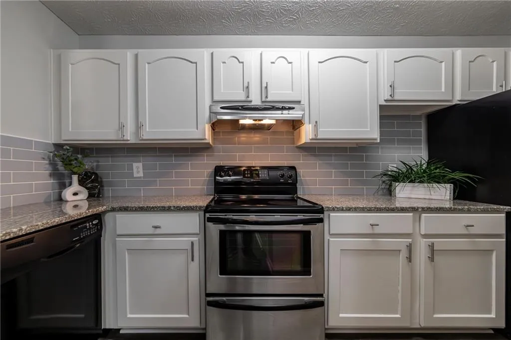 Kitchen with stainless steel range with electric cooktop, white cabinets, dishwasher, and refrigerator
