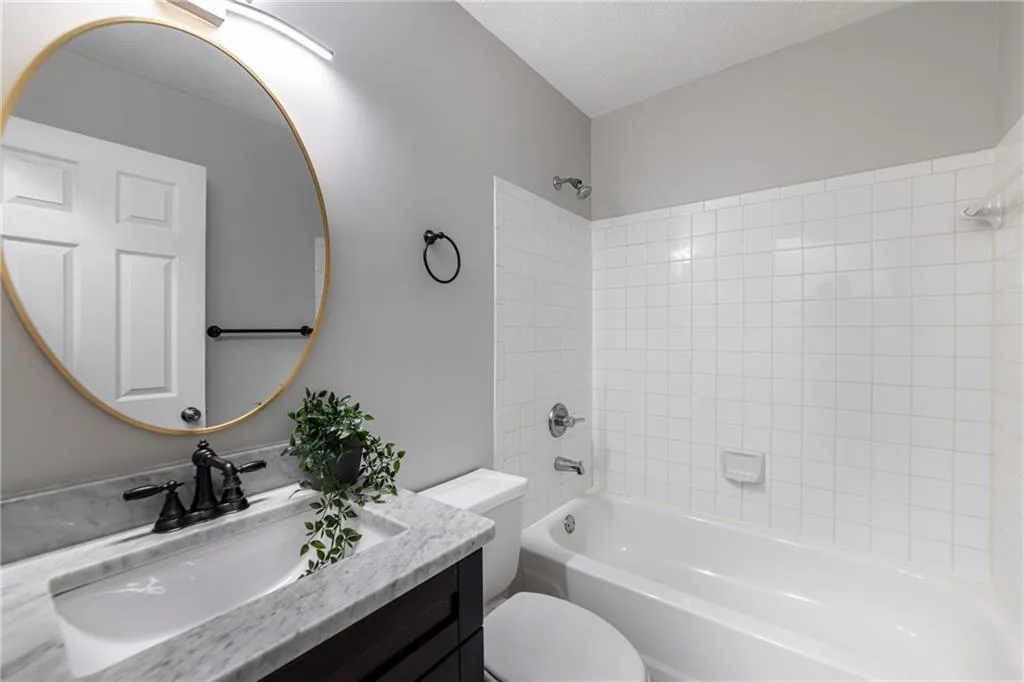 Bathroom with tub / shower combination, vanity, and a textured ceiling