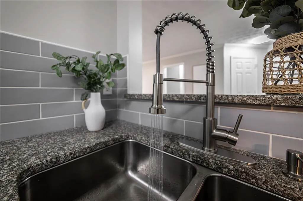 Kitchen view of dark stone counters and backsplash