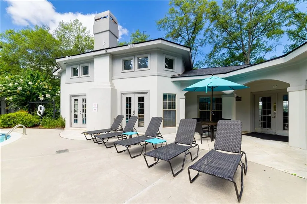 Rear view of house with french doors, a patio, a chimney, and stucco siding