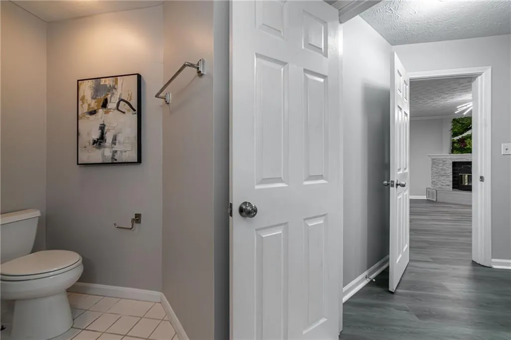 Bathroom with a textured ceiling, a fireplace, and tile patterned floors