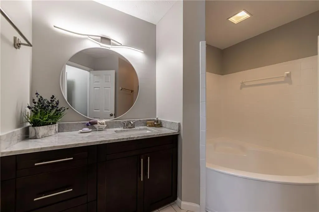 Bathroom with vanity, light tile patterned flooring, and shower / bath combination