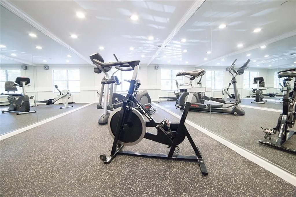 Workout area featuring crown molding, a wainscoted wall, and a decorative wall