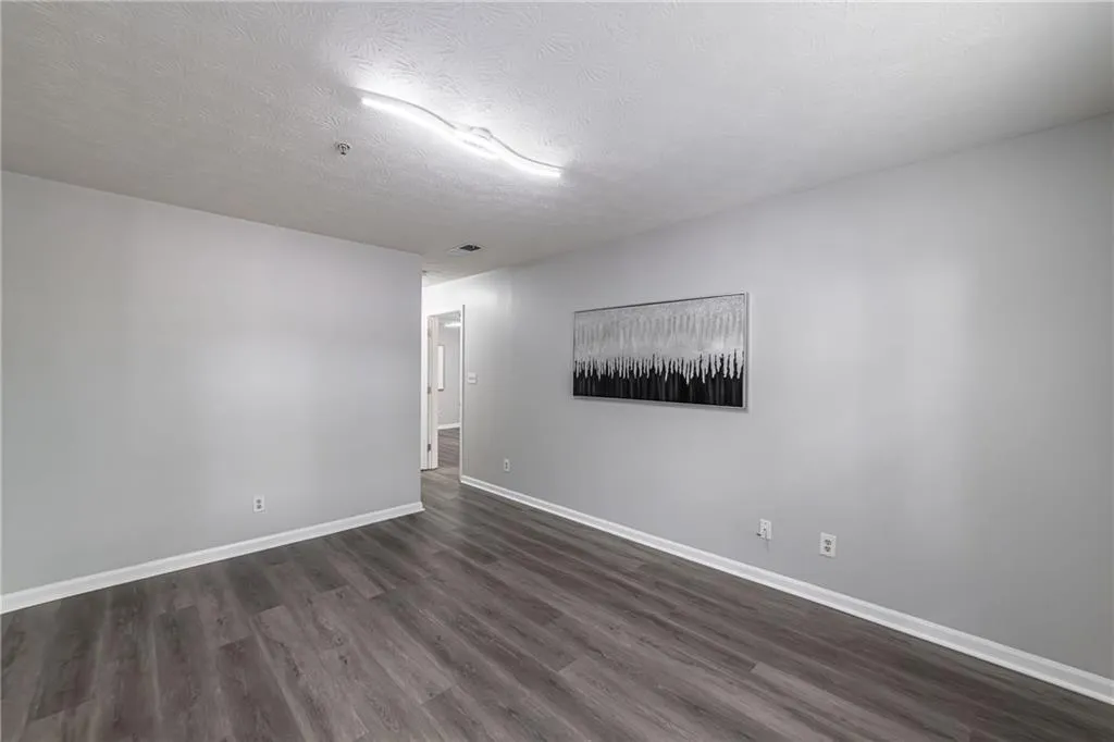 Spare room with dark wood-type flooring and a textured ceiling
