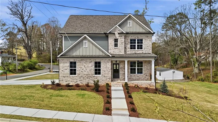 Craftsman inspired home featuring board and batten siding, a front yard, and covered porch