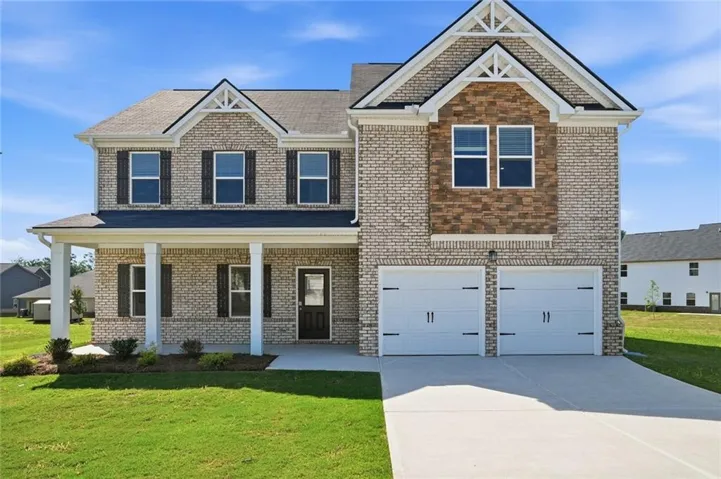 Two-story brick exterior featuring a covered front porch with white columns, dual gable accents, a two-car garage, and a concrete driveway