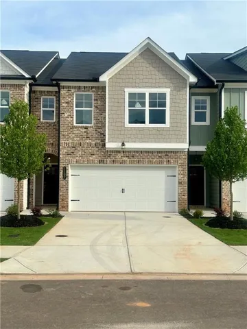 Contemporary townhome exterior featuring brick and shingle siding accents