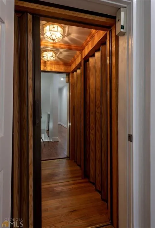 Hallway with elevator and wood finished floors