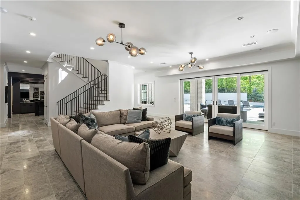 Spacious rec area on terrace level with recessed sliding doors to the pool and courtyard and access to the home gym, bar and game room