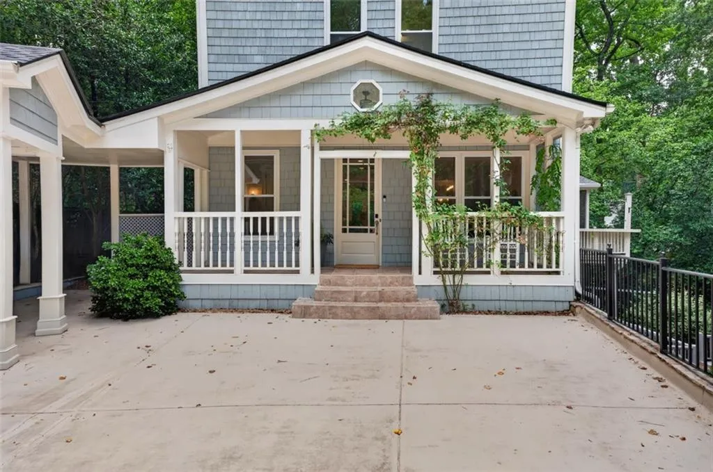 Light blue shingle siding exterior featuring a covered front porch with white railings and an adjacent screened porch