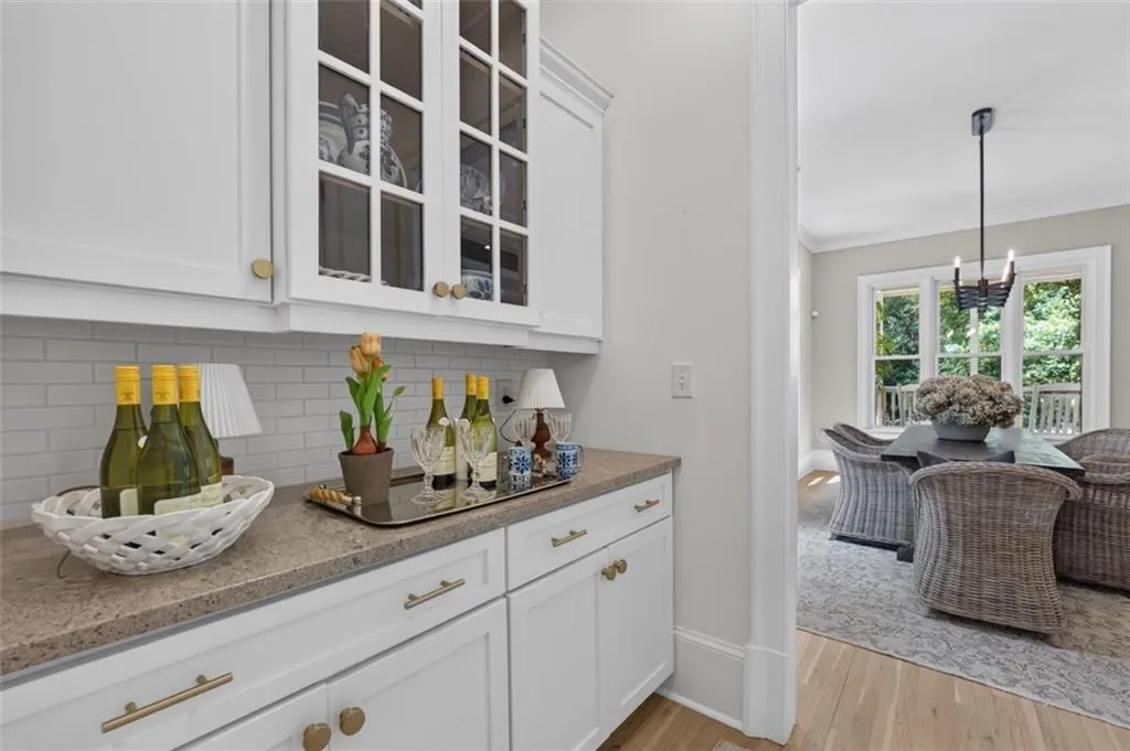 Built-in cabinetry with glass-front uppers and solid lower storage, complemented by a light-toned countertop and subway tile backsplash