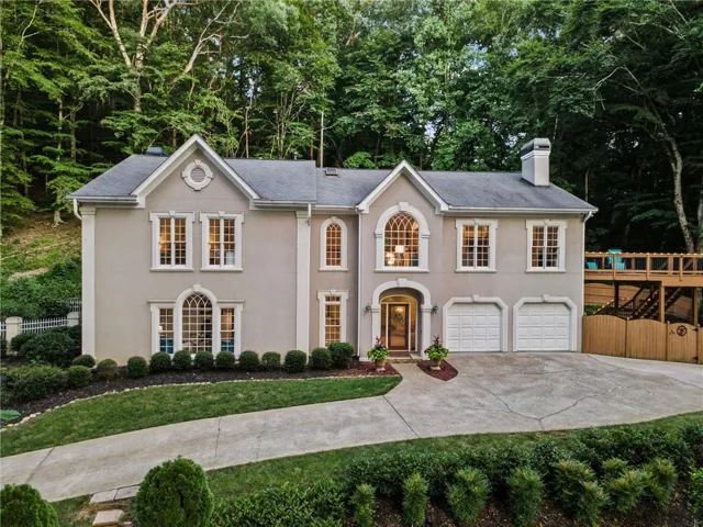 Exterior with arched and rectangular windows, a double-door entrance, and a two-car garage