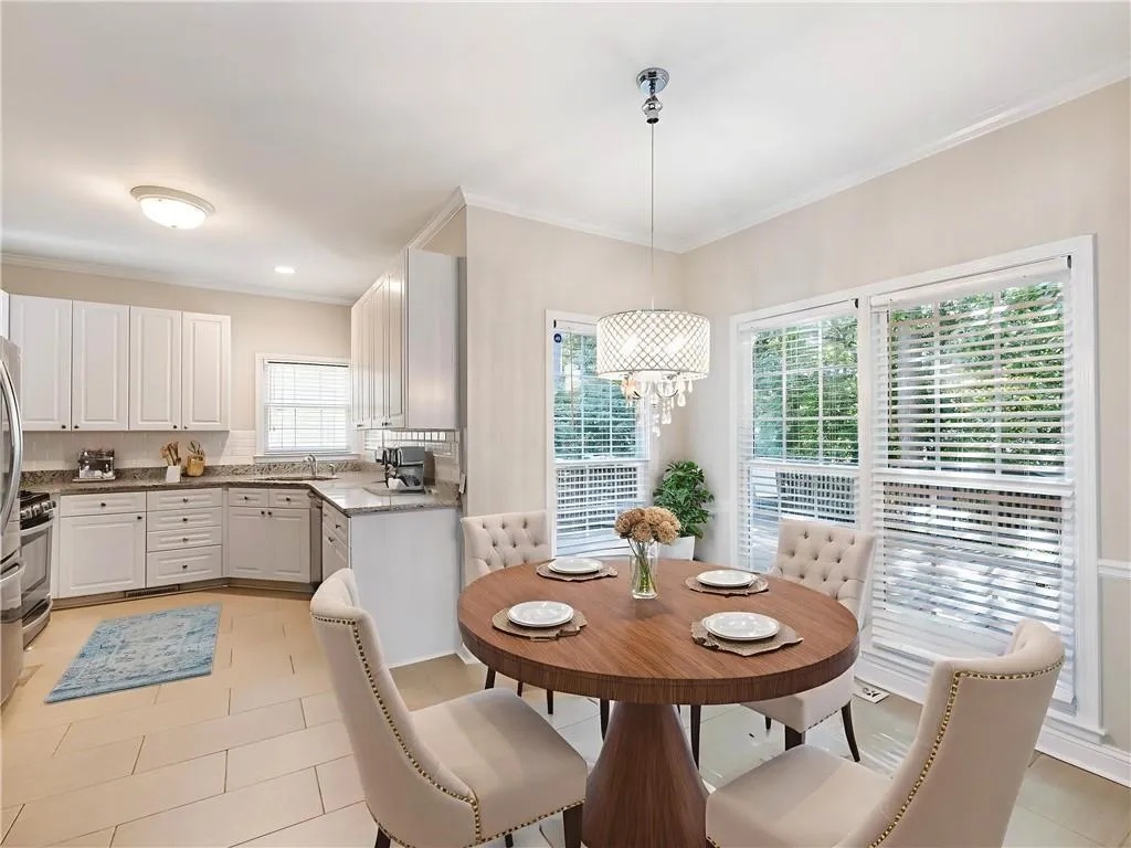 Dining area featuring ornamental molding, a chandelier, and light tile patterned floors