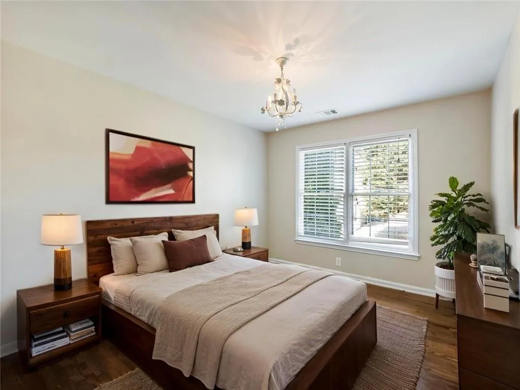 Bedroom featuring a chandelier and dark wood-type flooring