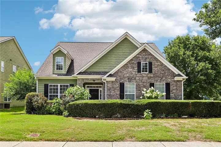 Stone veneer and siding exterior with a gabled roofline, dormer window, and dark shutters