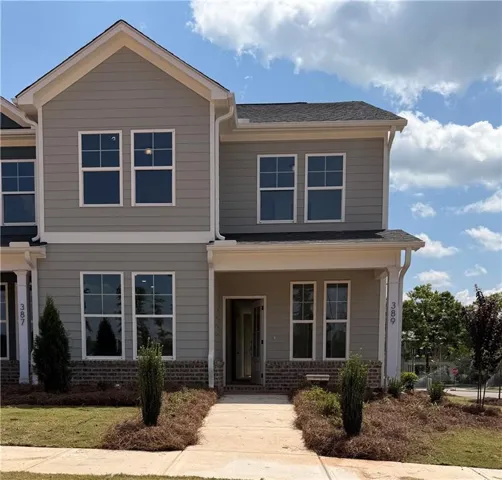 Two-story residence featuring light gray siding with white trim, a covered entry, and a dark shingle roof
