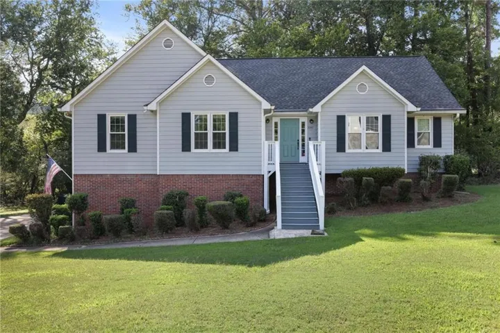 Light blue siding exterior with brick accents and dark shutters