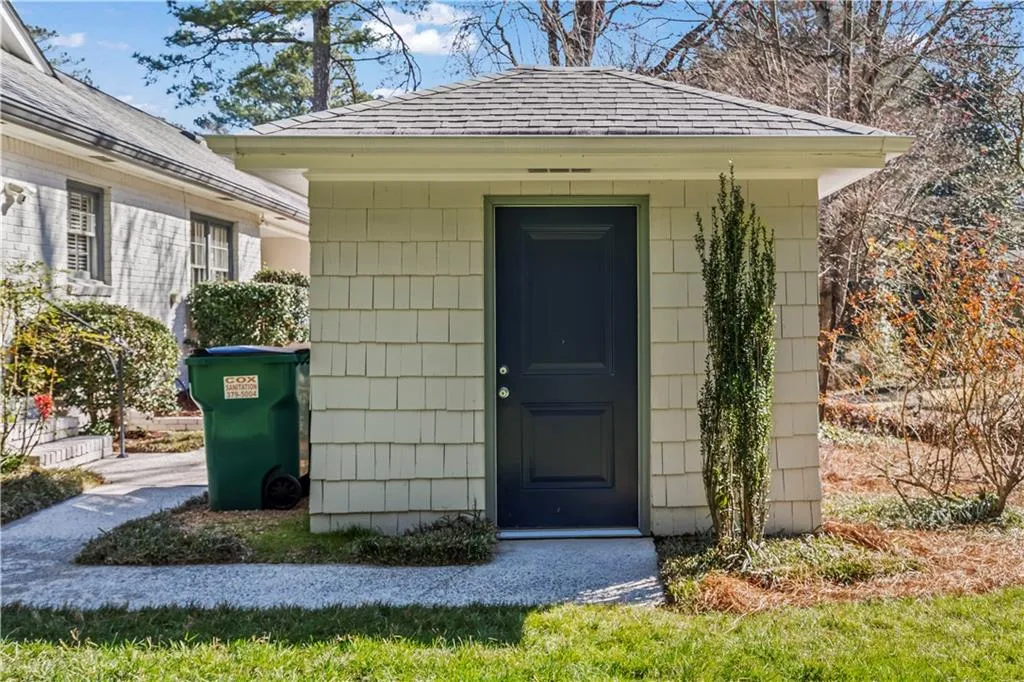 View of exterior entry featuring a shingled roof