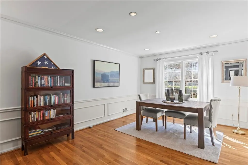 Dining space featuring a decorative wall, recessed lighting, ornamental molding, wainscoting, and light wood-type flooring