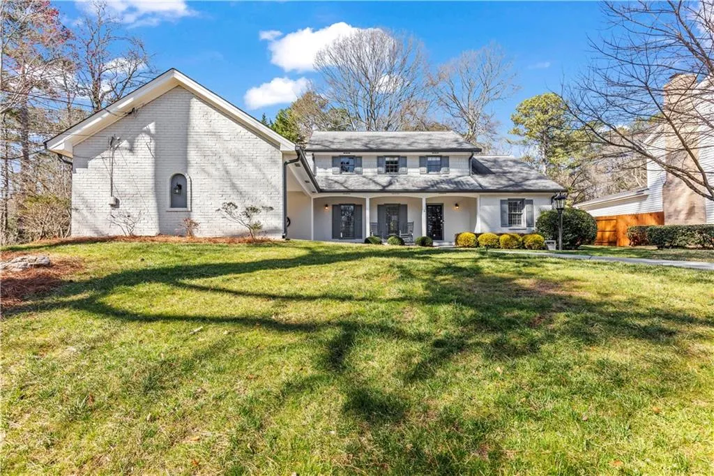 View of front of house featuring a front lawn and brick siding