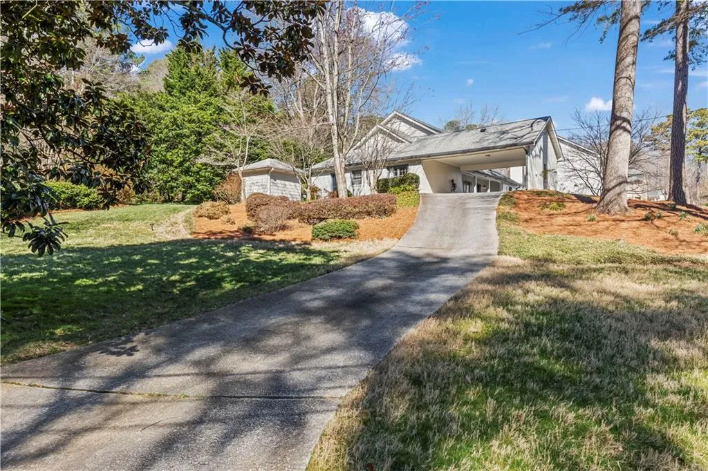 View of front of home with driveway, a carport, and a front yard