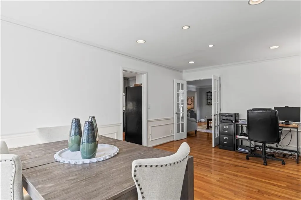 Dining area featuring a wainscoted wall, ornamental molding, wood finished floors, and recessed lighting