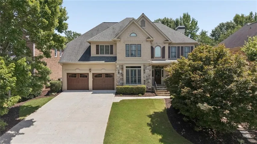 Stucco and stone facade sets the stage for this pristine home nestled on quiet tree line street in Christopher Robbins Swim/Tennis Community.