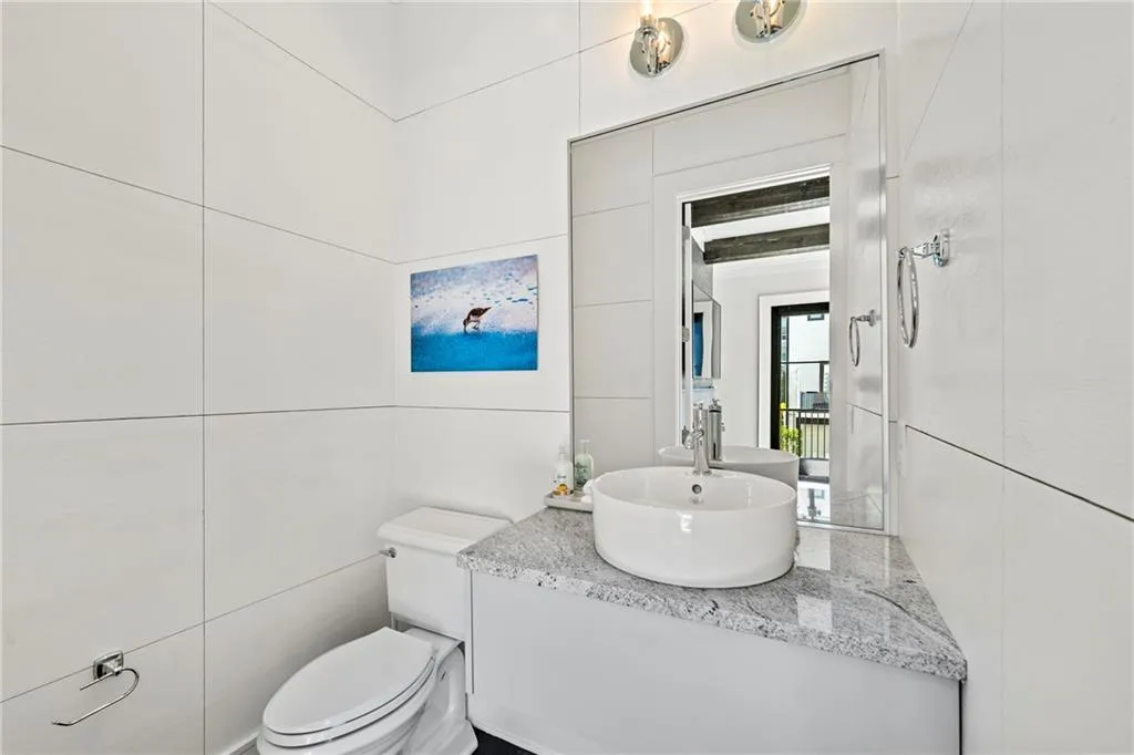 Half bathroom with vanity and tile walls