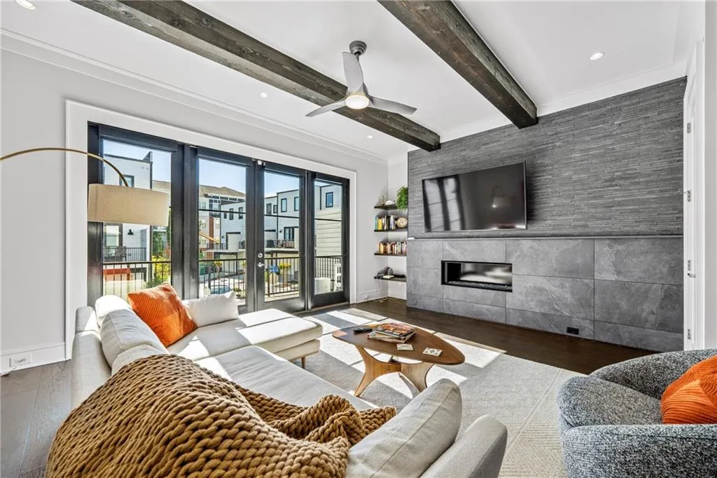 Living room featuring wood finished floors, beamed ceiling, a tile fireplace, a ceiling fan, and recessed lighting