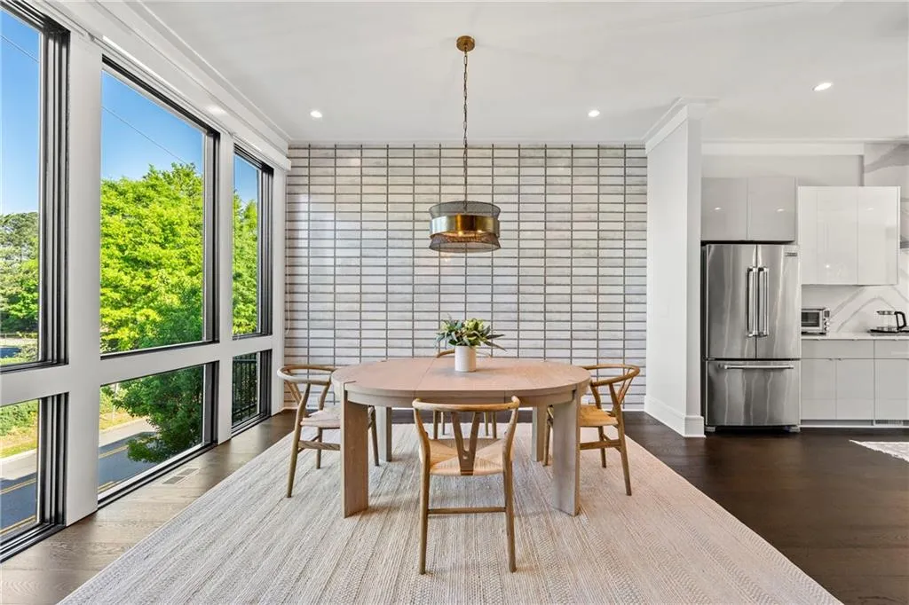 Dining space with dark wood-type flooring, recessed lighting, and tile walls