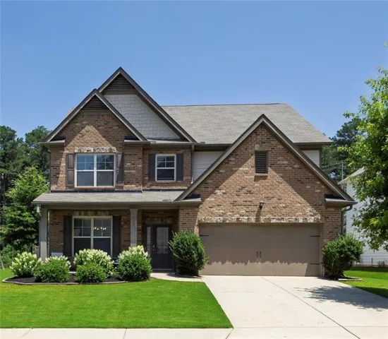 Two-story brick and siding residence featuring a covered front porch with pillar supports