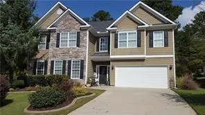 Two-story property featuring a stone and siding facade, contrasting dark shutters, a two-car garage, and a concrete driveway