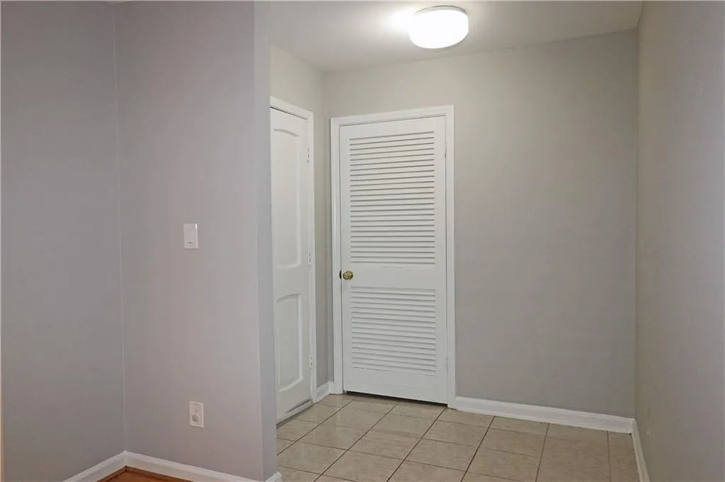 Unfurnished bedroom with light tile patterned flooring and a closet