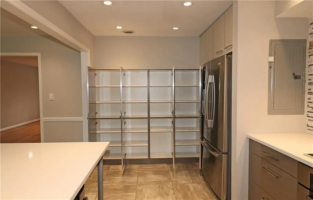 Kitchen featuring light countertops, recessed lighting, electric panel, appliances with stainless steel finishes, and modern cabinets
