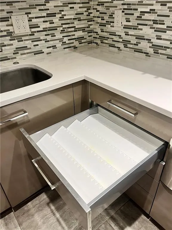 Kitchen view of tasteful backsplash and light stone countertops