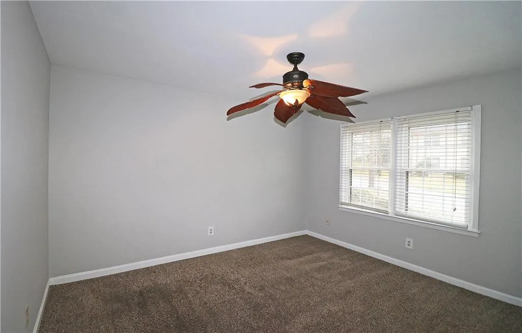 Spare room with dark carpet and ceiling fan