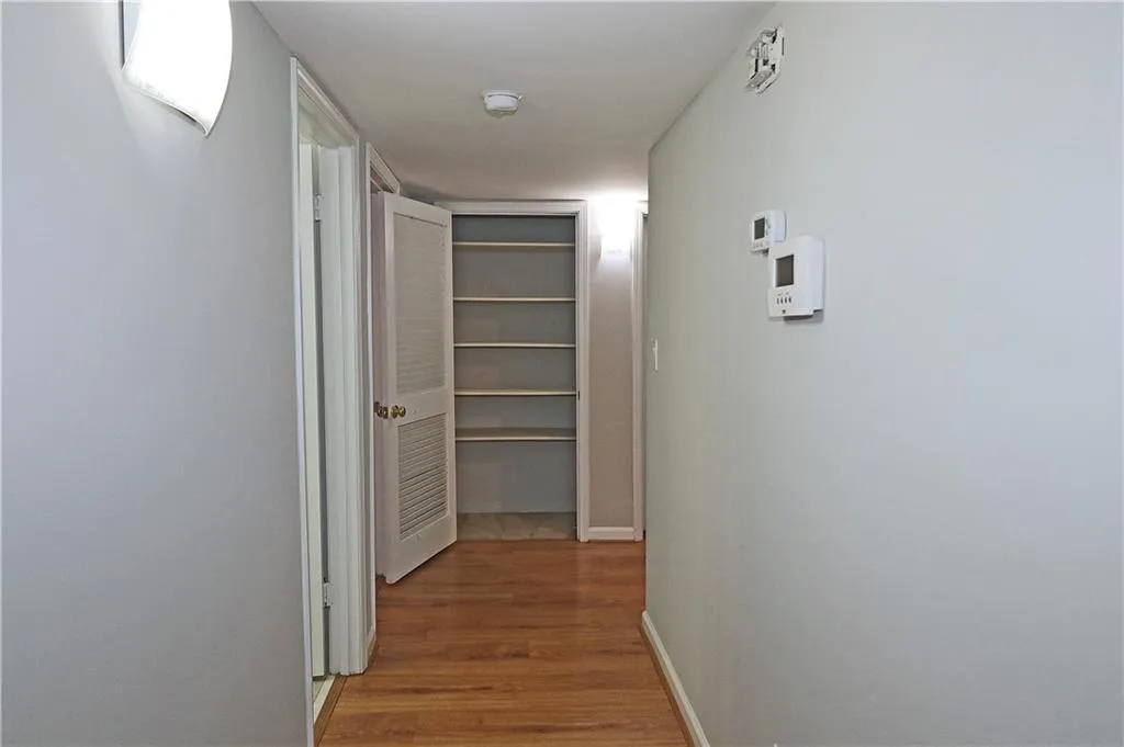Corridor with light wood-style flooring and baseboards