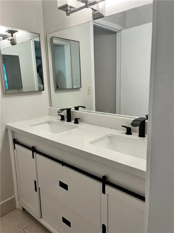 Bathroom featuring double vanity and light tile patterned flooring
