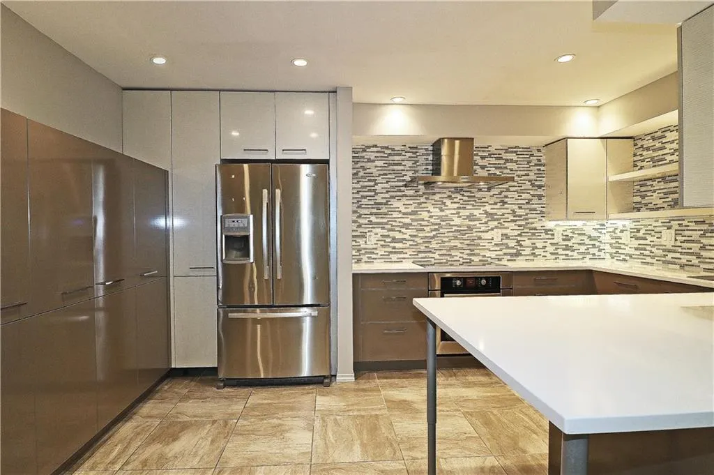 Kitchen with stainless steel appliances, open shelves, tasteful backsplash, wall chimney exhaust hood, and recessed lighting