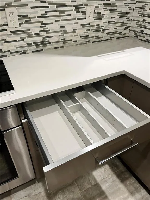 Kitchen view of beverage cooler, backsplash, and oven