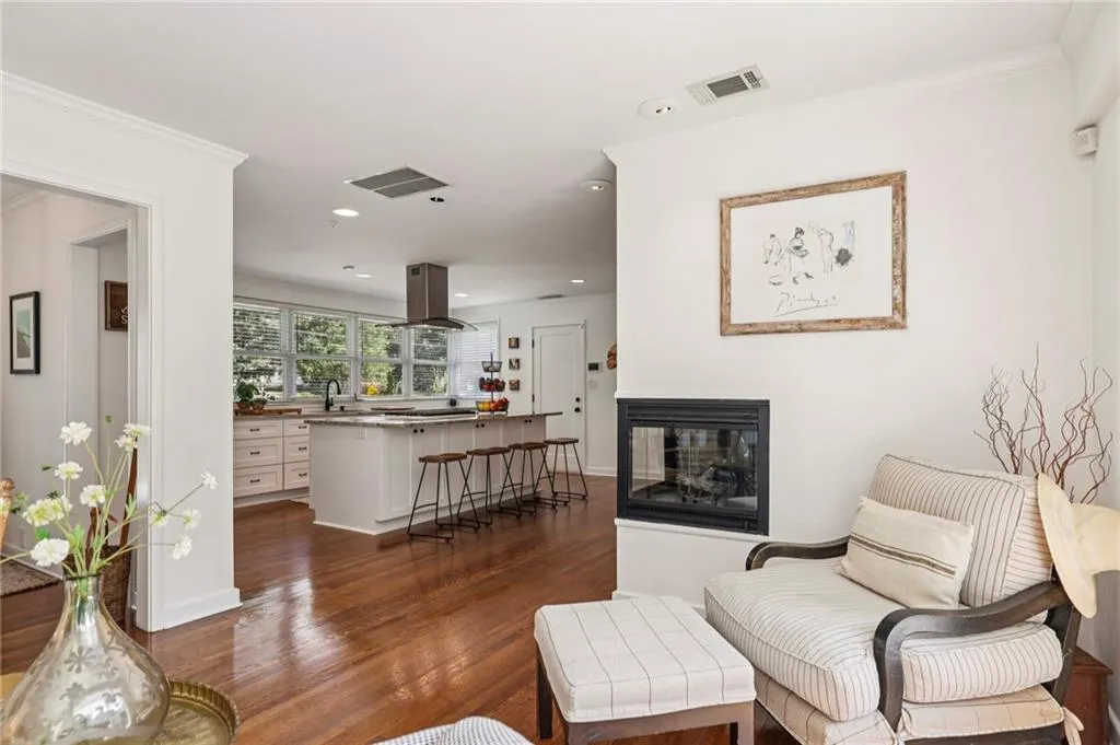 Living area with ornamental molding, dark wood-type flooring, and recessed lighting